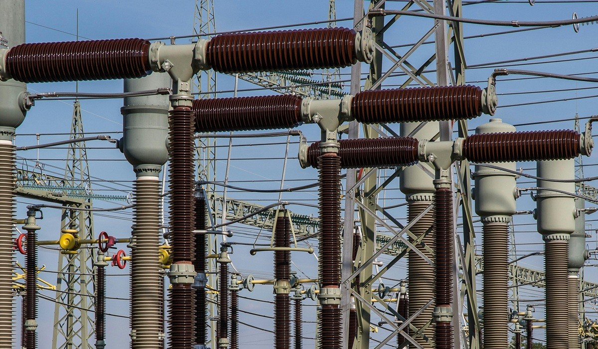 High-voltage electrical grid substation with transformers and transmission lines