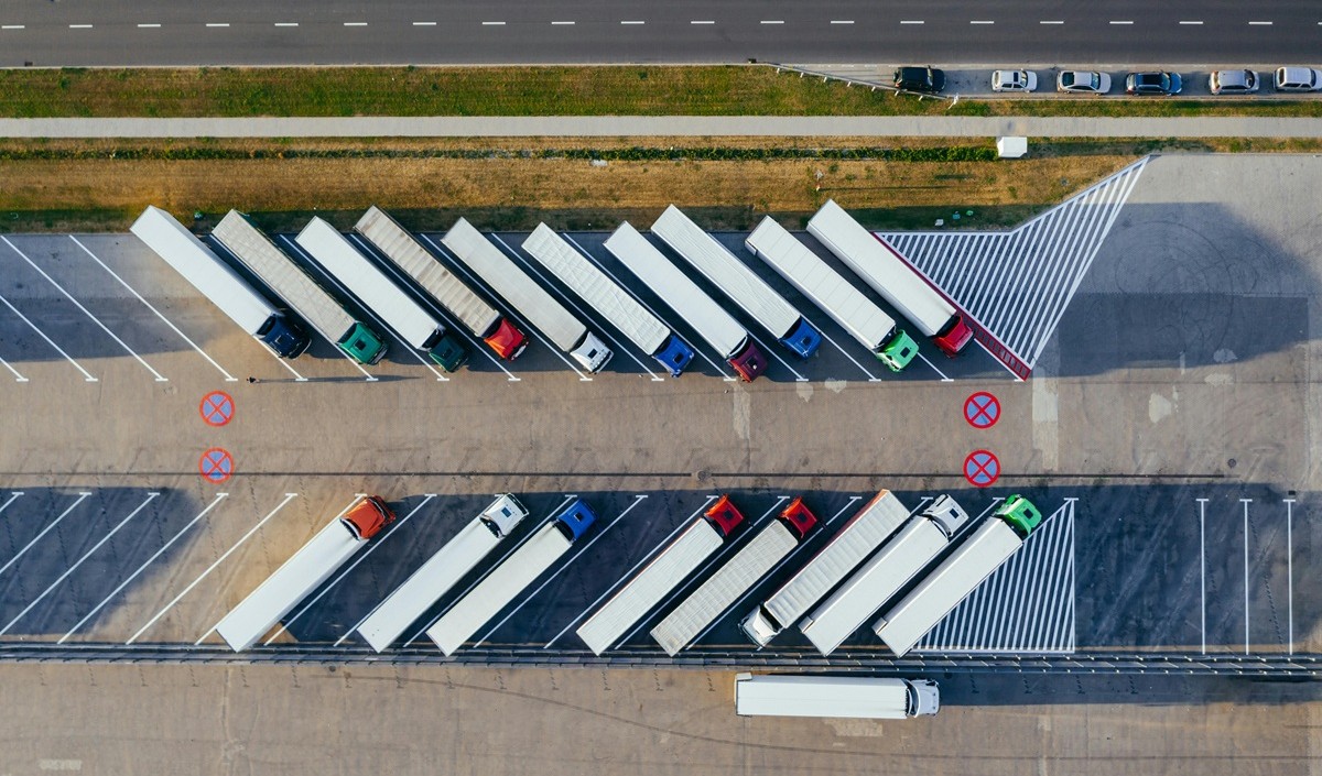 Aerial view of a fleet of delivery trucks parked in a logistics hub